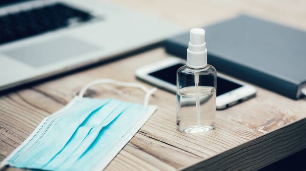 image of an antiseptic spray next to a laptop on the table. - 写真・画像