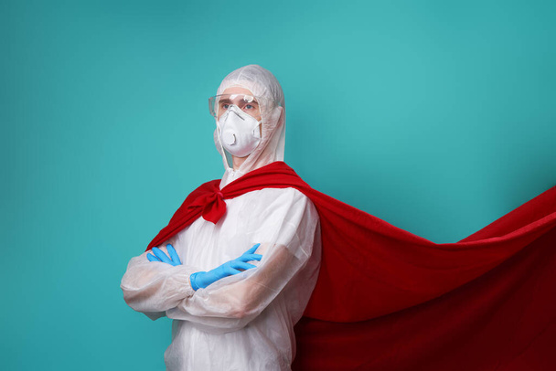 Dottore indossa PPE - costume, guanti e maschera chirurgica in mantello supereroe
. - Foto, immagini