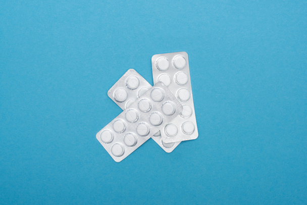 top view of pills in blister packs on blue background - Fotografie, Obrázek