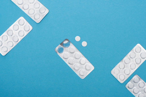vista superior de las píldoras en blisters sobre fondo azul
 - Foto, Imagen