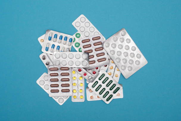 top view of colorful pills in blister packs on blue background - Photo, Image