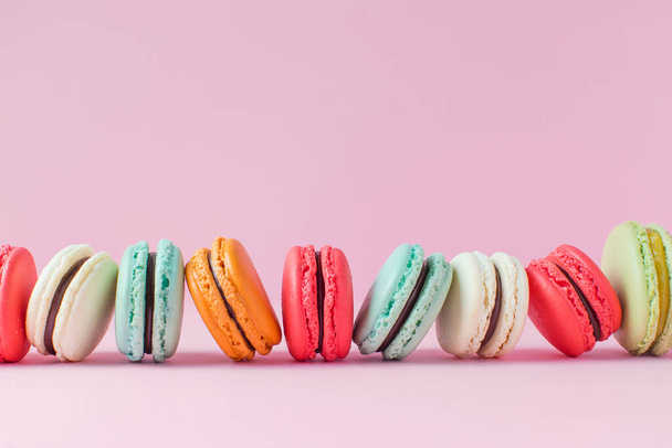 Beautiful colourful desserts. french macaroons on a pink background - Foto, imagen