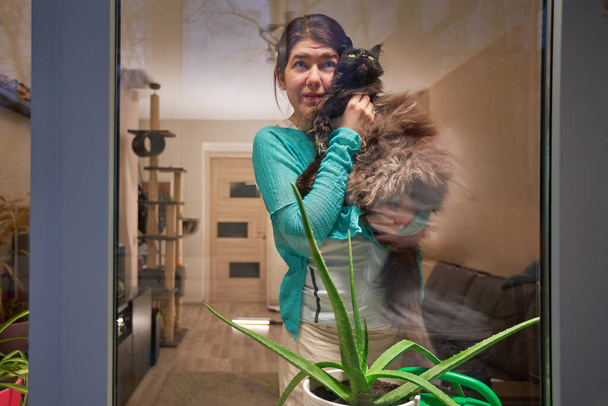 Woman with cat stay at home, selfisolation to prevent spread infection. - Photo, Image