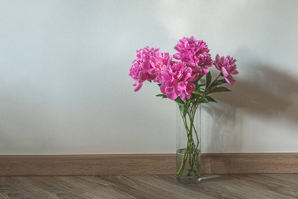 Γυάλινο βάζο με ροζ παιώνιες στο ξύλινο πάτωμα - Φωτογραφία, εικόνα