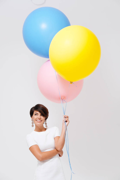 portrait laughing woman with bunch of colorful balloons  - Фото, изображение