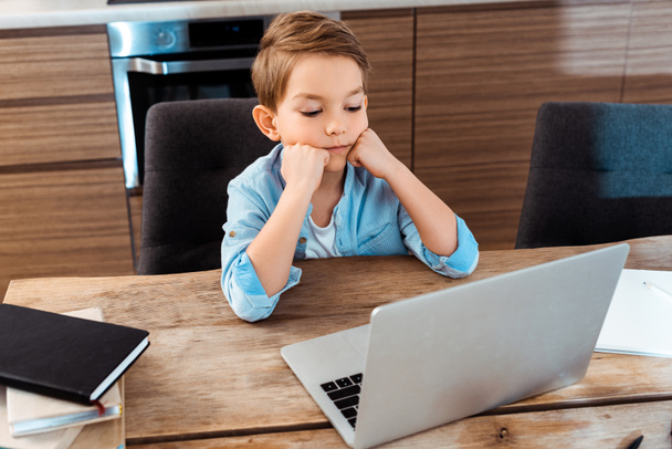enfoque selectivo del niño aburrido mirando a la computadora portátil mientras e-learning en casa
 - Foto, Imagen