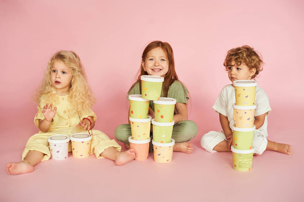 Group of happy kids playing with paper boxes. Eco packaging and disposable tableware. Idea for packaging. - Фото, зображення