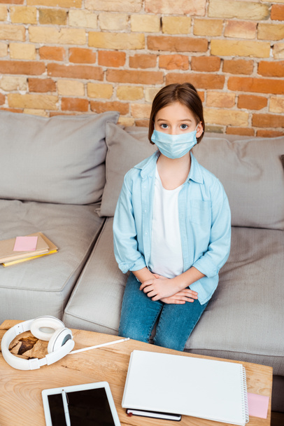 kid in medical mask near digital tablet with blank screen and headphones  - Photo, Image