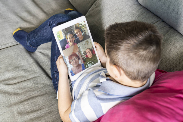 Nahaufnahme eines kleinen Kindes, das zu Hause per Videochat mit der Familie spricht - Foto, Bild