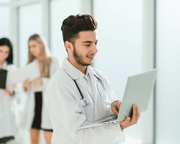 doctor therapist uses a laptop while standing in the hallway of - Foto, imagen