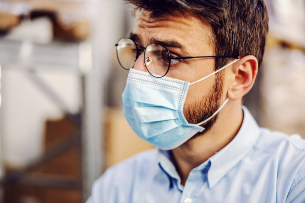 Closeup of handsome businessman wearing protective sterile mask. - Photo, Image