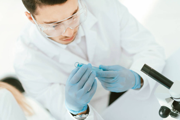 Confident young male scientist holding test tube - Fotó, kép