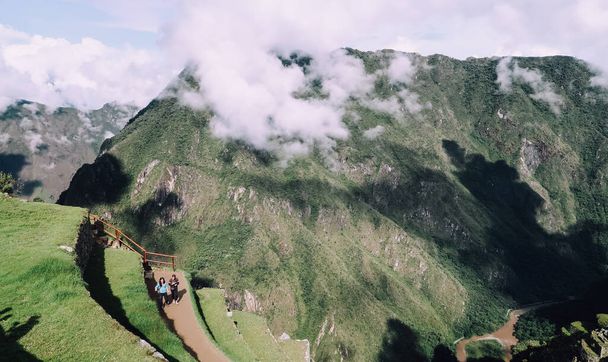 MACHU PICCHU, PERU - CIRCA NOVEMBER 2019: iconic view of the lost city Machu Picchu with view of the mountains and clouds. - Foto, afbeelding