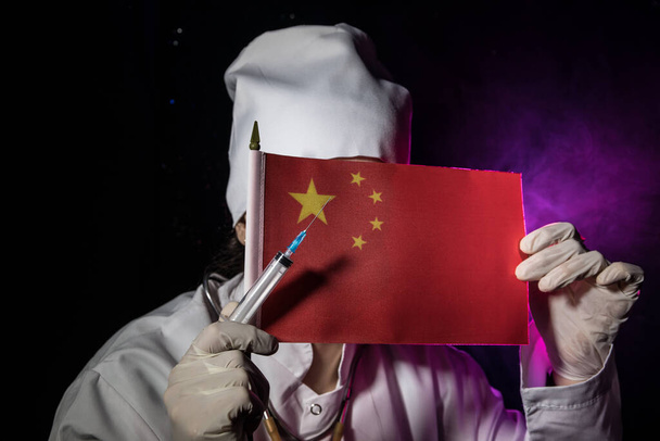 Femme médecin masquée tenant le drapeau chinois. Peur de la maladie, virus de la couronne 2019-2020. Virus, épidémie et maladie de masse, concept du virus Corona
. - Photo, image