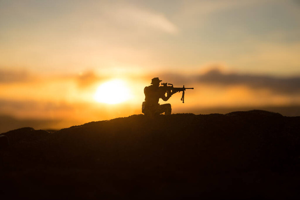 Oorlogsconcept. Militaire silhouetten vechtscène op oorlog mist lucht achtergrond, Wereldoorlog Soldaten Silhouet Onder bewolkt Skyline zonsondergang. Selectieve focus - Foto, afbeelding