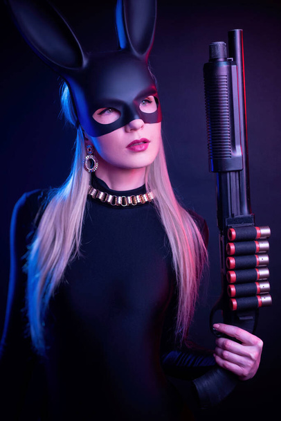 meisje in een konijn masker met een shotgun - Foto, afbeelding