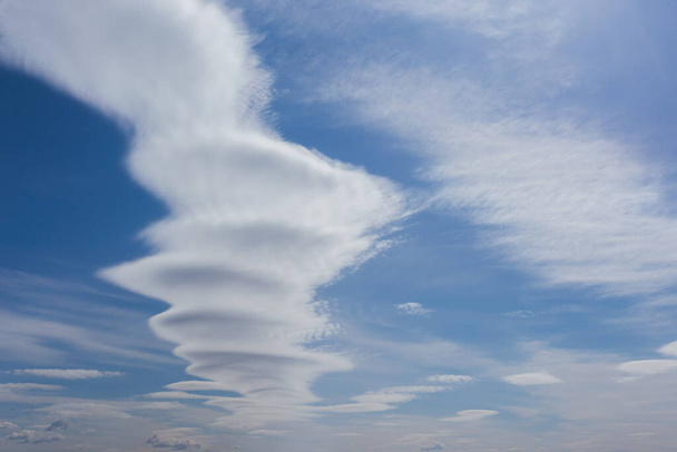 Unusual clouds against a blue sky, a cloud in the form of an explosion or mushroom, swirls - Zdjęcie, obraz