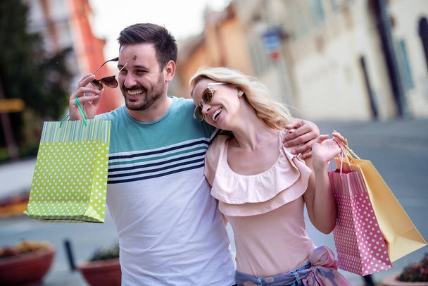 Alışveriş yaptıktan sonra alışveriş torbalarıyla mutlu bir çiftin portresi.. - Fotoğraf, Görsel