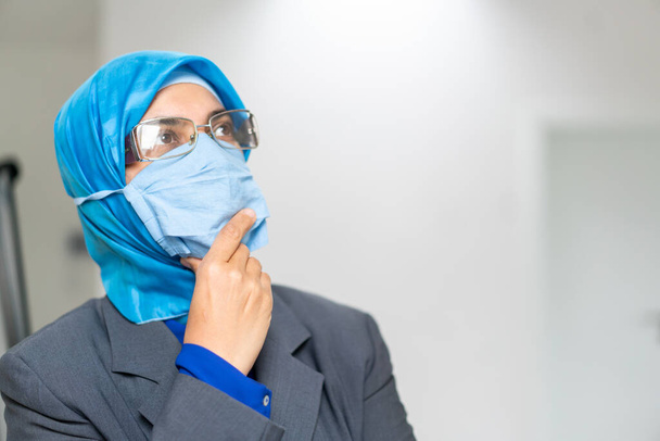 Médico muçulmano tecendo máscara protetora
 - Foto, Imagem