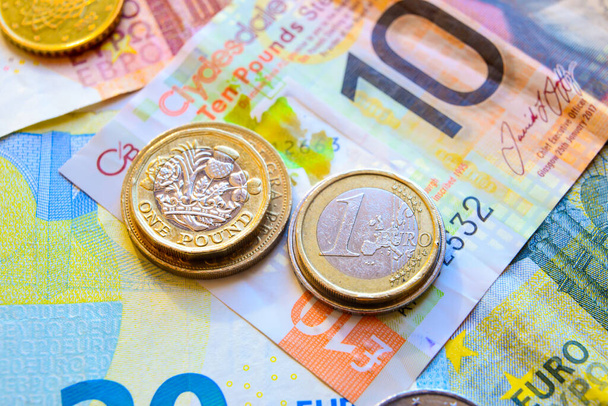 Moedas e notas de euro e de Pund; Euro vs Libra
 - Foto, Imagem