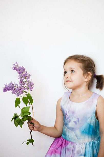 little girl in a dress with a branch of lilac, blooming branch, baby, daughter, beauty - 写真・画像