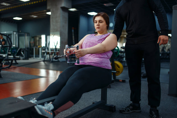 Túlsúlyos nő, edzővel a sportklubban, fitnesz edzés az oktatóval. Női személy küzd a túlsúly, aerob edzés az elhízás ellen, tornaterem - Fotó, kép