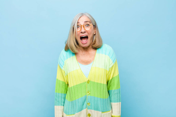 senior or middle age pretty woman feeling terrified and shocked, with mouth wide open in surprise - Fotoğraf, Görsel
