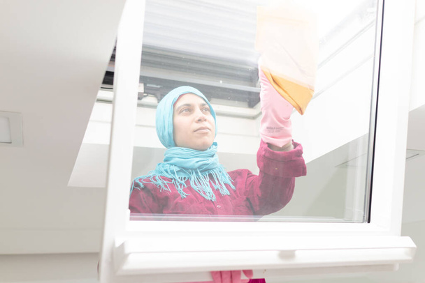 イスラム教徒の女性のリビングルームで窓を掃除 - 写真・画像
