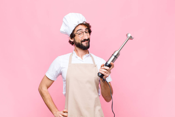 young crazy cool man with a hand blender against pink wall - Foto, Imagem