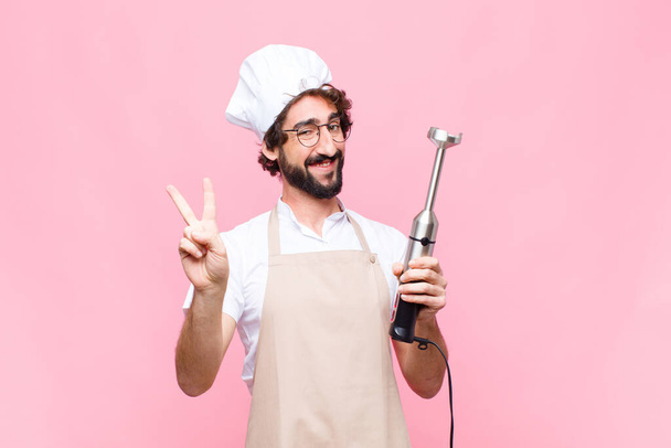 young crazy cool man with a hand blender against pink wall - Fotoğraf, Görsel