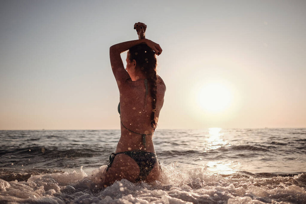 Kaunis emotionaalinen malli tyttö tekee tilkka meressä ja nauraa. Kaunis nainen kuuma tyttö nauttii meren aallot. Trooppinen loma - Valokuva, kuva
