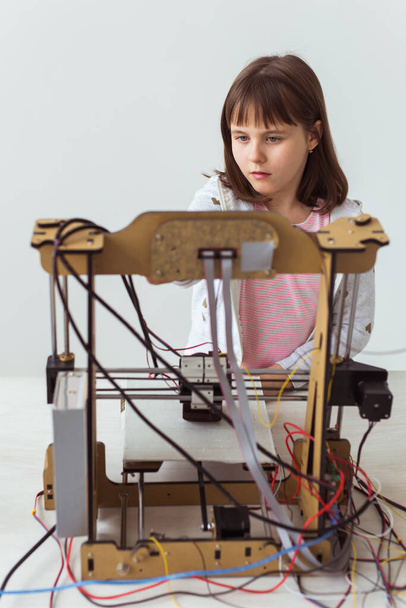 3Dプリンタを使用して小さな子供の建築家。女子高生,技術と研究の概念. - 写真・画像