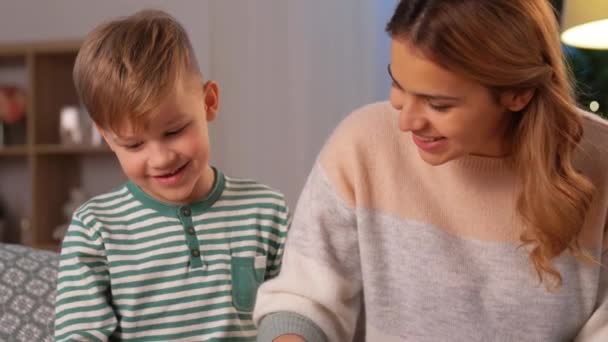 mother and son playing with toy cars at home - Video