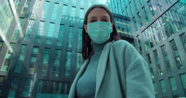 Woman in face mask standing in business district - Video