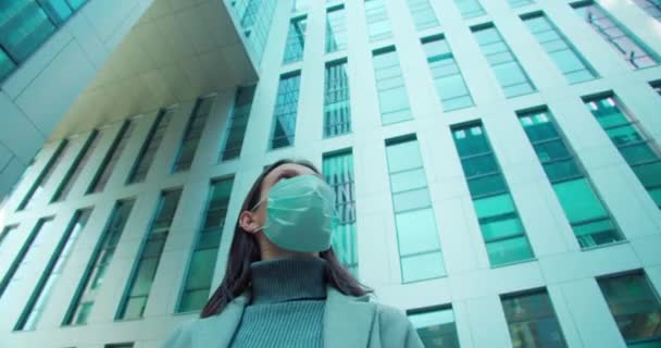 Woman in face mask standing in business district - Video
