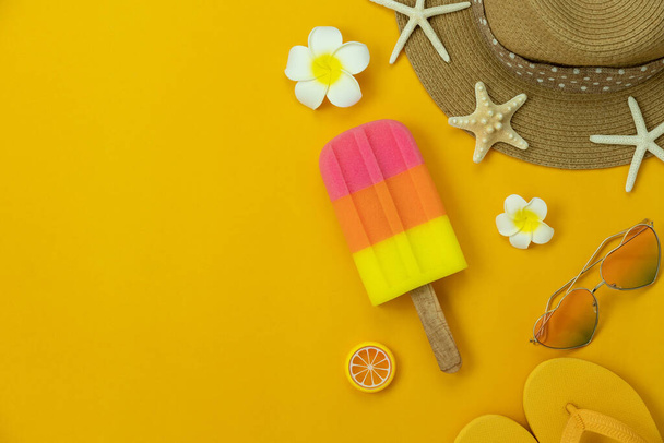Table top view accessory of clothing women  plan to travel in Hello summer holiday background concept.Ice cream with many essential items hat & sandals flower, starfish on yellow paper.copy space. - Photo, Image