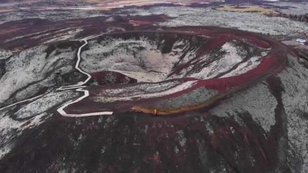 İzlanda, Avrupa 'da çöl geçmişi olan, volkanik krater yolunda yürüyüş yapan maceraperest bir çiftin hava görüntüsü.  - Video, Çekim