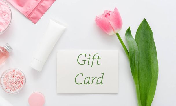 Gift card with pink flower on white background from beauty salon cosmetics perfumery shop. Gift card present coupon for woman. Surprise voucher for Mother's Day, Happy Birthday, anniversary, wife. - Фото, изображение
