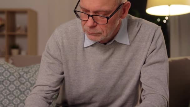 senior man counting money at home - Кадри, відео