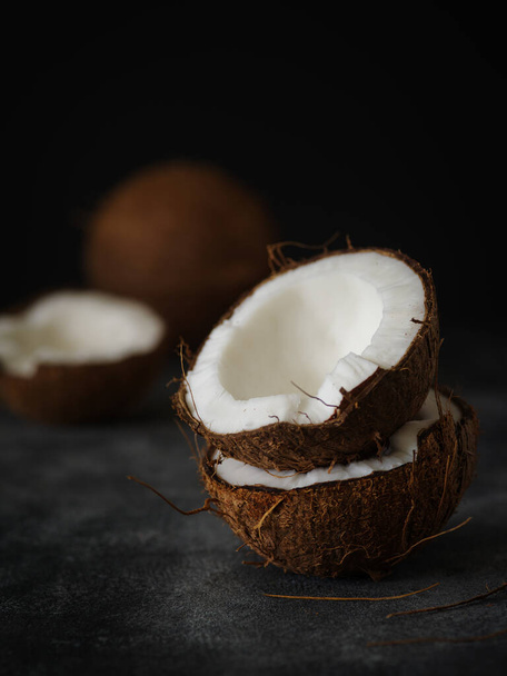 Połówki kokosów na ciemnym tle - Zdjęcie, obraz