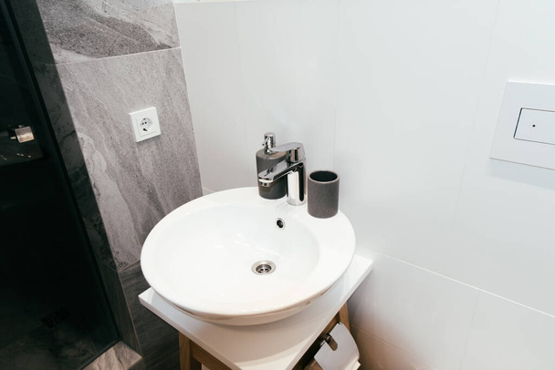 moderno interno del bagno con lavabo bianco e dispenser di sapone
 - Foto, immagini