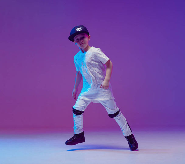 Cool young boy child dancing hip hop in the Studio against the background of neon lights. Break dance poster. - Foto, Imagem