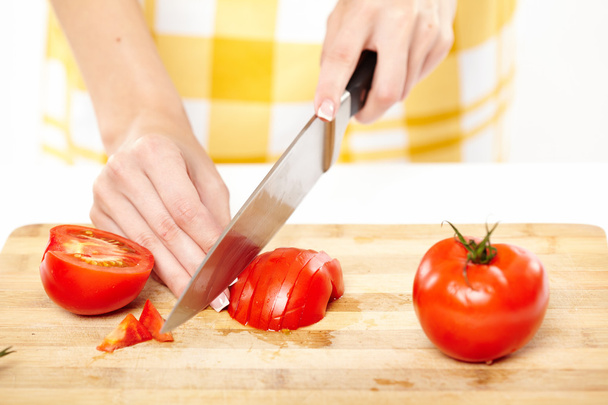 Slicing the tomato on a wooden board - Φωτογραφία, εικόνα