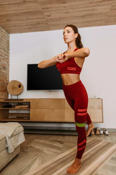 attractive sportswoman training online with resistance band on fitness mat at home during self isolation  - Fotografie, Obrázek