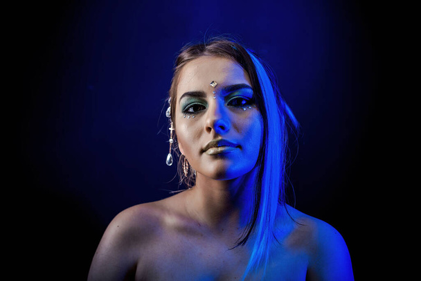 ethnic girl on a black background in blue light - Fotoğraf, Görsel