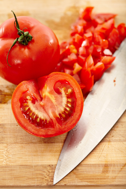 Freshly chopped tomatoes on a wooden board - Foto, afbeelding