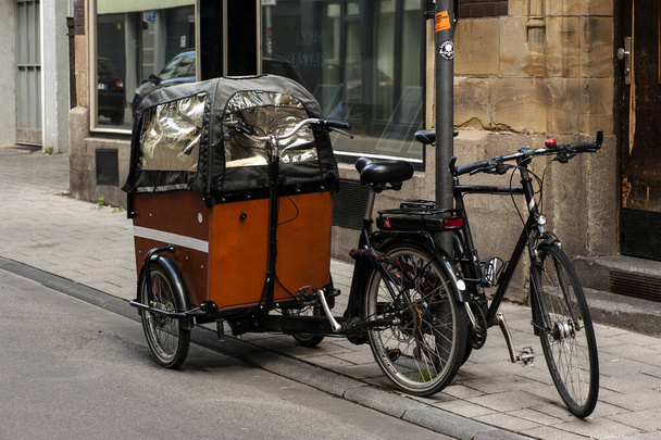 COLOGNE, NÉMETORSZÁG 2020. május 2.: Elektromos tehergépjármű-kerékpár egy út menti parkolóban Kölnben. - Fotó, kép