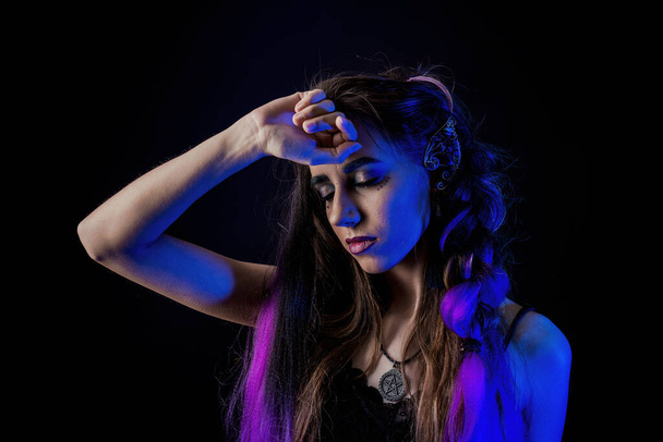 Girl in werewolf style on a black background with blue light. - Фото, зображення