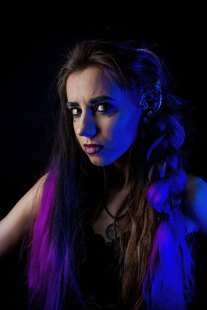 Girl in werewolf style on a black background with blue light. - Photo, Image