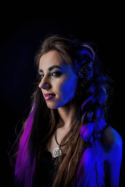 Girl in werewolf style on a black background with blue light. - Фото, изображение